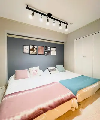 a bedroom with two beds with pink and blue at Alo BnB 6 - Near IKEBUKURO, SHINJUKU, UENO, AKIHABARA - Self check-in in Tokyo