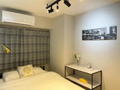a bedroom with a bed and a table with a night stand at Alo BnB 6 - Near IKEBUKURO, SHINJUKU, UENO, AKIHABARA - Self check-in in Tokyo