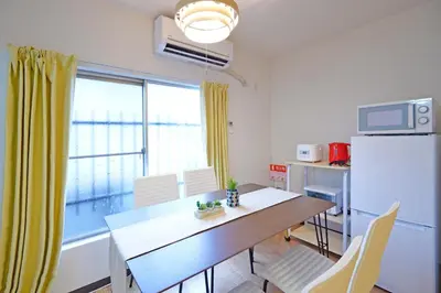 a kitchen and dining room with a table and a refrigerator at YUZU HOUSE in Tokyo