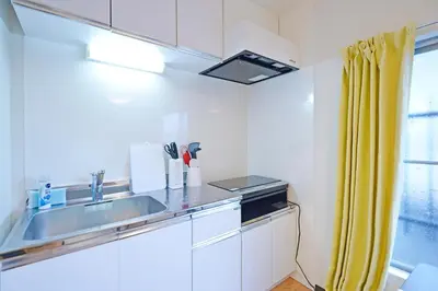 a kitchen with a sink and a yellow curtain at YUZU HOUSE in Tokyo