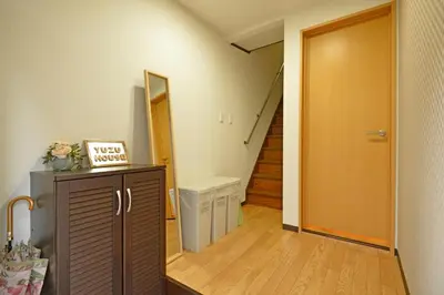 a hallway with a door leading to a hallway with a staircase at YUZU HOUSE in Tokyo
