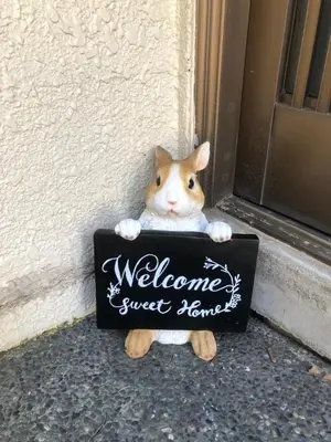 a stuffed cat holding a welcome sweet home sign at YUZU HOUSE in Tokyo