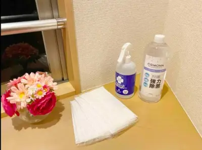 a counter with a bottle of bleach and a vase of flowers at Tsunoya in Tokyo