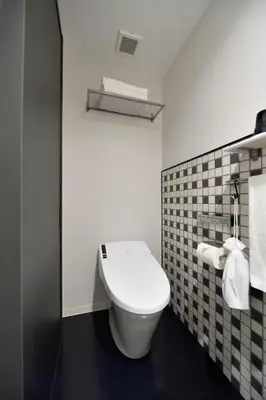 a white toilet in a bathroom with a black floor at HOTEL TAVINOS ASAKUSA - Vacation STAY 64889 in Tokyo