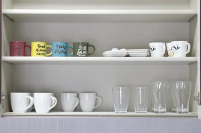 a shelf with many cups and glasses on it at Comfy Home Koiwa in Tokyo