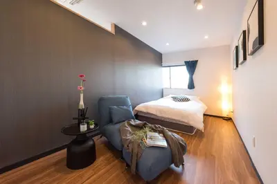 a bedroom with a bed and a blue chair in a room at TORA HOTEL Tokyo Skytree \u5bc5\u30db\u30c6\u30eb \u30b9\u30ab\u30a4\u30c4\u30ea\u30fcF in Tokyo