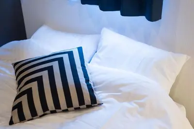 a bed with white sheets and a pillow on it at TORA HOTEL Tokyo Skytree \u5bc5\u30db\u30c6\u30eb \u30b9\u30ab\u30a4\u30c4\u30ea\u30fcF in Tokyo
