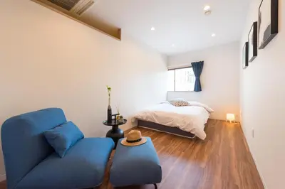 a living room with a blue couch and a bed at TORA HOTEL Tokyo Skytree \u5bc5\u30db\u30c6\u30eb \u30b9\u30ab\u30a4\u30c4\u30ea\u30fcD in Tokyo