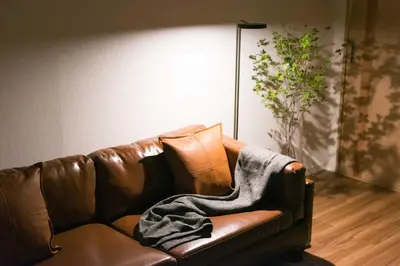 a brown leather couch with a blanket on it at TORA HOTEL Tokyo Skytree \u5bc5\u30db\u30c6\u30eb \u30b9\u30ab\u30a4\u30c4\u30ea\u30fcD in Tokyo