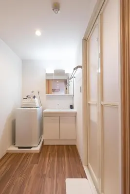 a small kitchen with white cabinets and wood floors at TORA HOTEL Tokyo Skytree \u5bc5\u30db\u30c6\u30eb \u30b9\u30ab\u30a4\u30c4\u30ea\u30fcB in Tokyo