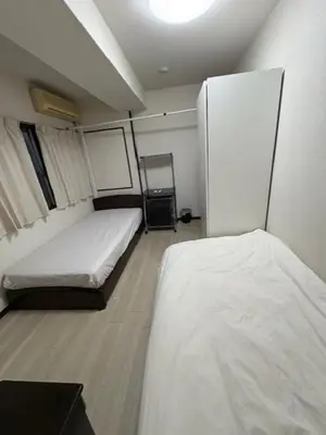 a room with two beds and a refrigerator at Tokyo Kakan in Tokyo