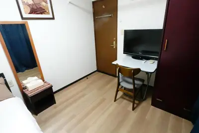 a room with a desk with a television and a bed at Tokyo Kakan in Tokyo