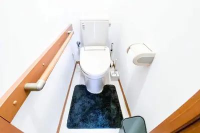 a bathroom with a toilet with a blue rug at Yahiro 4-chome House 1F in Tokyo