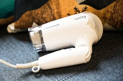 a white electric hair dryer sitting on a table at Yahiro 4-chome House 1F in Tokyo