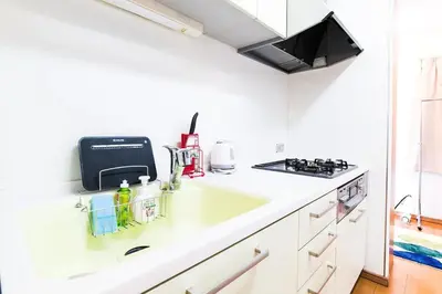 a white kitchen with a sink and a stove at Yahiro 4-chome House 1F in Tokyo