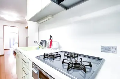 a kitchen with a stove top oven next to a sink at Yahiro 4-chome House 1F in Tokyo