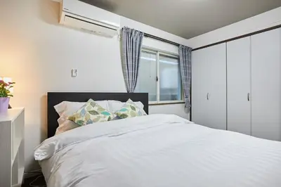 a bedroom with a white bed and a window at Ka's house in Tokyo