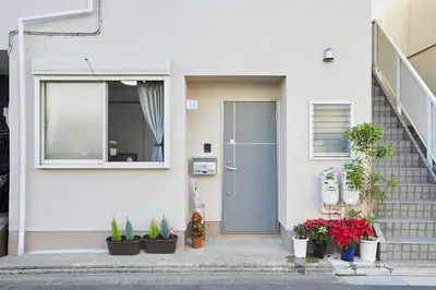 a front door of a white house with potted plants at Ka's house in Tokyo