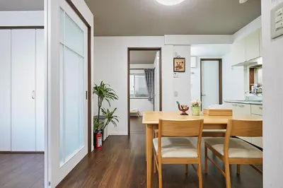 a kitchen and dining room with a wooden table and chairs at Ka's house in Tokyo