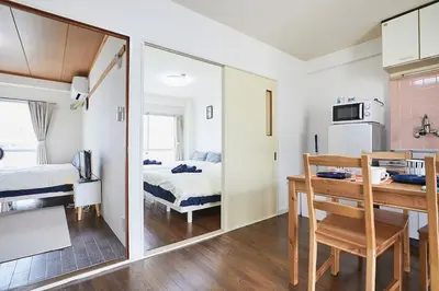a room with a bed and a table and a mirror at Sun white Gyoutoku 303 in Tokyo