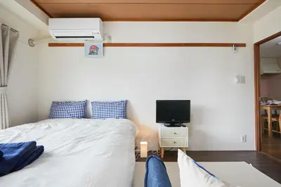 a bedroom with a bed and a tv on a wall at Sun white Gyoutoku 303 in Tokyo