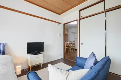 a living room with blue chairs and a tv at Sun white Gyoutoku 202 in Urayasu