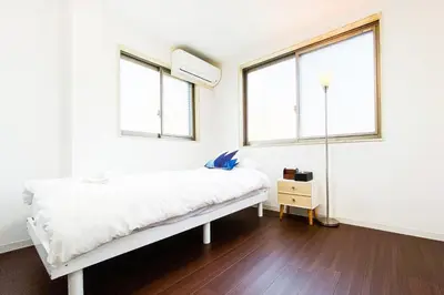 a white room with a bed and two windows at Yahiro 4-chome House 2F,3F in Tokyo