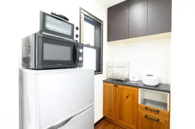 a small kitchen with a refrigerator and a microwave at Yahiro 4-chome House 2F,3F in Tokyo