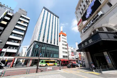 a city street with tall buildings and a yellow bus at Asakusa Tobu Hotel in Tokyo