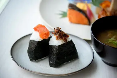 two pieces of sushi on a plate next to a bowl of soup at Asakusa Tobu Hotel in Tokyo