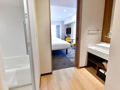 a bathroom with a mirror and a bedroom with a bed at Asakusa Tobu Hotel in Tokyo