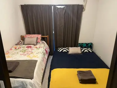 a bedroom with two beds and a window with curtains at H2O Stay Kikukawa Woody Sunheim #201 in Tokyo