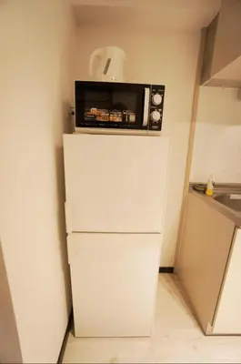 a microwave sitting on top of a white refrigerator at H2O Stay Kikukawa Woody Sunheim #201 in Tokyo