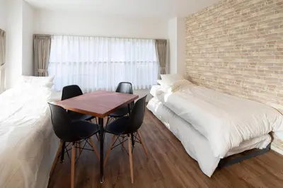 a bedroom with a bed and a table and chairs at Hotel Litlle Bird OKU-ASAKUSA in Tokyo