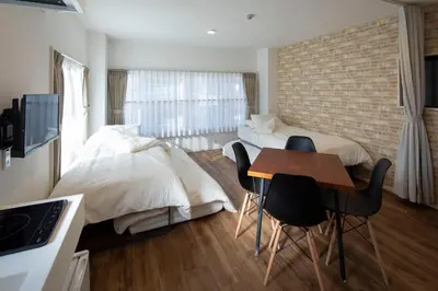 a bedroom with a bed and a table and chairs at Hotel Litlle Bird OKU-ASAKUSA in Tokyo