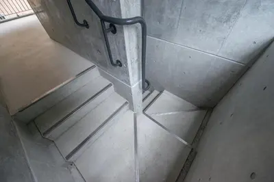 an overhead view of a metal hand rail on a staircase at bmj Hyakunincho in Tokyo
