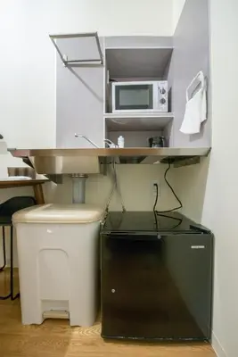 a kitchen with a sink and a microwave at bmj Hyakunincho in Tokyo