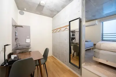 a room with a dining table and a bedroom at bmj Hyakunincho in Tokyo