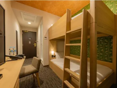 a bedroom with a bunk bed with a desk and a desk at Tosei Hotel Cocone Asakusa Kuramae in Tokyo