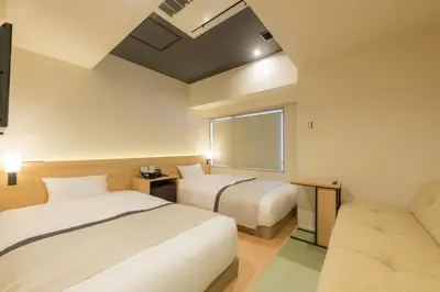 a hotel room with two beds and a window at Tosei Hotel Cocone Ueno Okachimachi in Tokyo