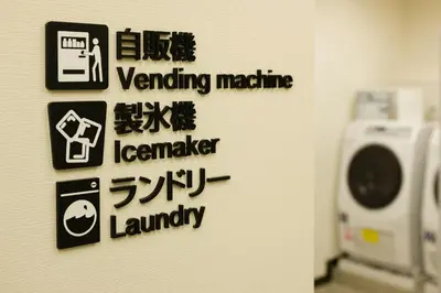 a wall with signs on the wall of a bathroom at Tosei Hotel Cocone Ueno Okachimachi in Tokyo