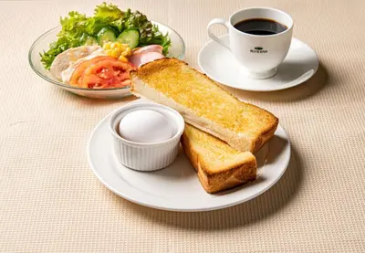 a plate with toast and a cup of coffee and a salad at Tosei Hotel Cocone Ueno Okachimachi in Tokyo