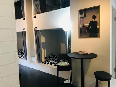 a room with a table and two stools in a room at Hostel 1010 TOKYO in Tokyo