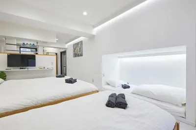 two beds with slippers on them in a bedroom at STAY ARI Kabukicho in Tokyo