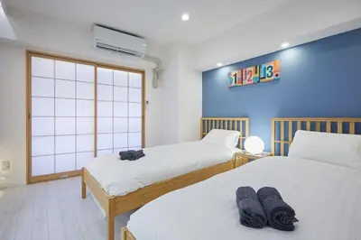 a bedroom with two beds and a window at STAY ARI Kabukicho in Tokyo