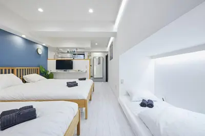 a room with three beds and a tv at STAY ARI Kabukicho in Tokyo