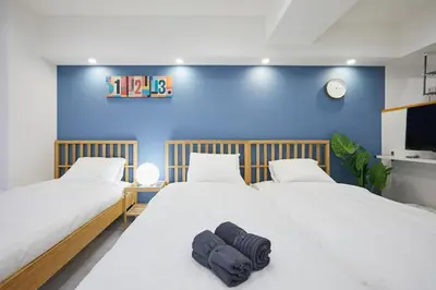 two beds in a room with a blue wall at STAY ARI Kabukicho in Tokyo