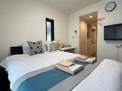 a bedroom with a large bed with towels on it at nestay inn tokyo kagurazaka in Tokyo