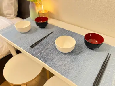 a table with three bowls and chopsticks on it at nestay inn tokyo kagurazaka in Tokyo