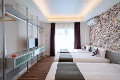 a hotel room with four beds and a tv at Hotel SAILS Asakusa in Tokyo